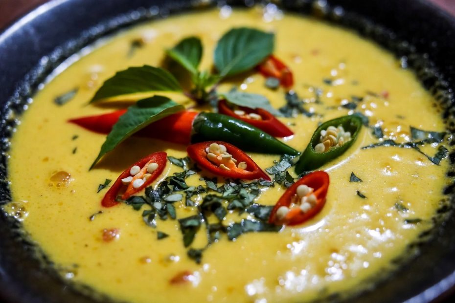 Close-up Paniki santan pedas dengan kuah kuning kental dan daun kemangi segar